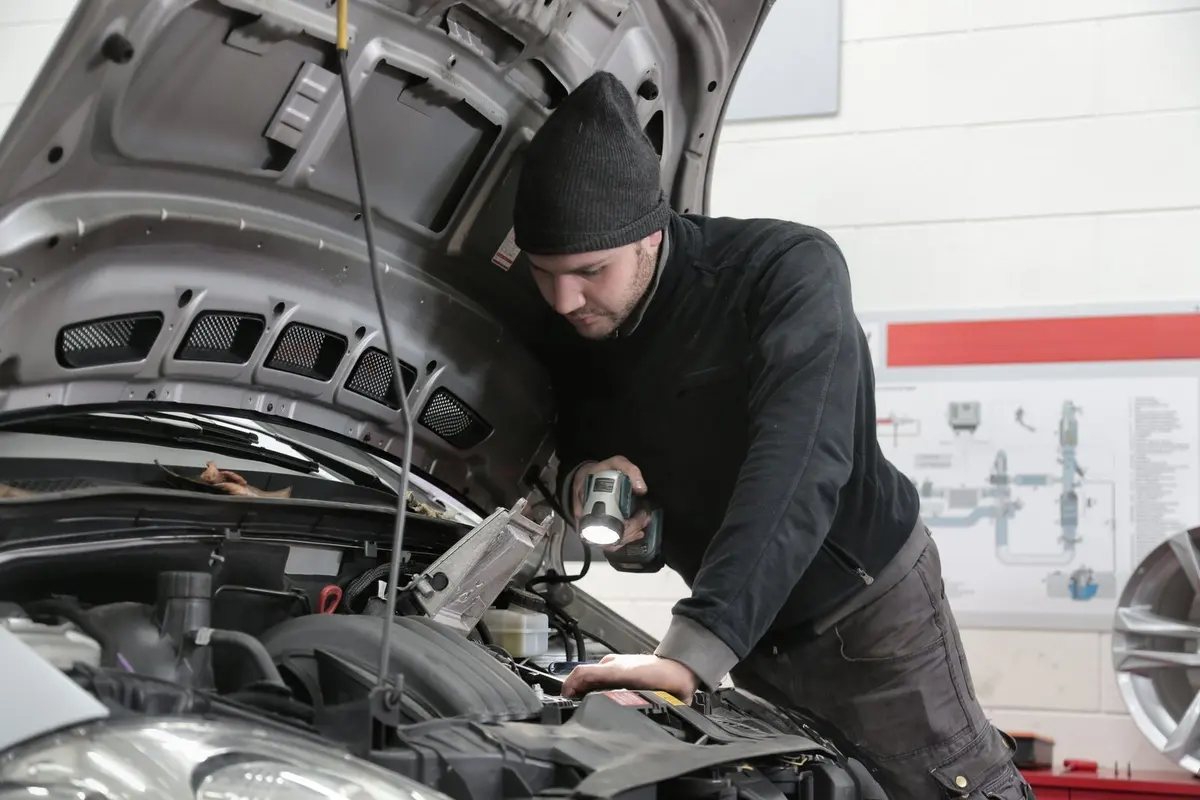 Mechanic checking an engine with a flashlight