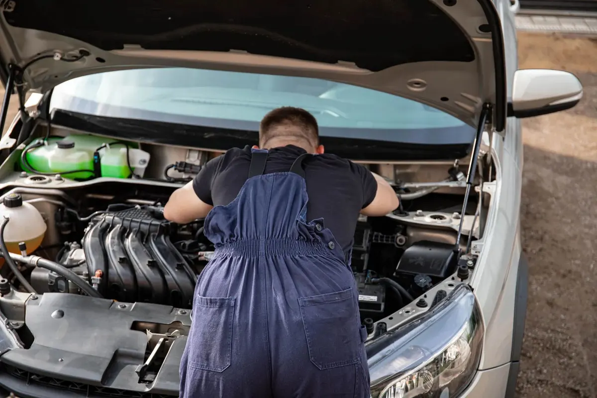 Mechanic leaning into an open engine bay